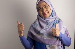 ritratto contento maturo asiatico musulmano donna mostrando dubbioso mano gesto isolato su bianca sfondo foto