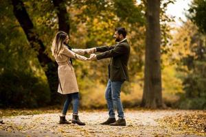 giovane coppia avendo divertimento nel il autunno parco foto