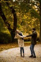 giovane coppia avendo divertimento nel il autunno parco foto