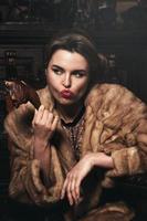 provocatorio Immagine di donna indossare pelliccia cappotto e mangiare affumicato pollo gamba. animale diritti concetto. foto