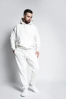 bello uomo indossare vuoto bianca felpa con cappuccio e pantaloni foto