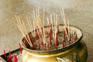 tradizionale incensiere con fumante bastoni dentro un' buddista tempio. foto
