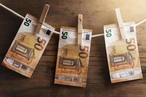 cinquanta Euro banconote siamo essiccazione su un' bianca corda, tenuto di mollette. foto