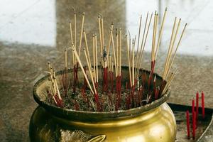 tradizionale incensiere con fumante bastoni dentro un' buddista tempio. foto