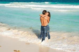 bellissimo coppia indossare jeans su il tropicale spiaggia foto