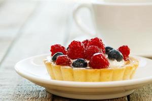 torta con frutti di bosco e tazza di caffè foto