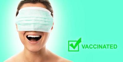 sorridente donna indossare maschera al di sopra di sua occhi è avuto sua vaccino per virus foto