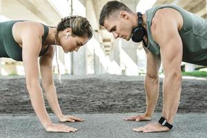 atletico coppia e fitness formazione all'aperto. uomo e donna fare sollevamento esercizio. foto