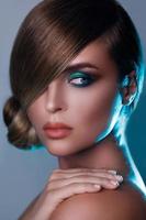 modello nel elegante Immagine con elegante capelli copertura uno occhio e bellissimo verde ombretti su un altro foto