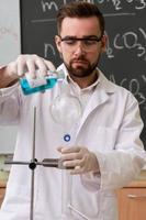scienziato è scrosciante sostanza in il condensatore nel un' laboratorio durante ricerca foto