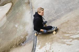 giovane portatori di handicap tipo con un' longboard nel un' Skate park foto