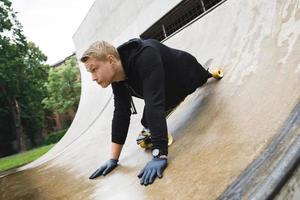 giovane portatori di handicap tipo con un' longboard nel un' Skate park foto