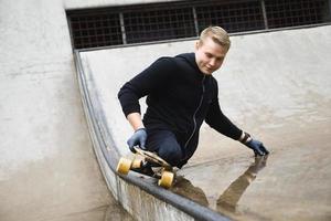 giovane portatori di handicap tipo con un' longboard nel un' Skate park foto