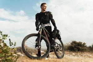 discesa ciclista completamente attrezzata con protettivo Ingranaggio e il suo bicicletta foto
