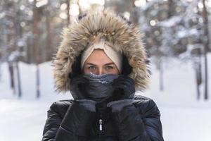 giovane donna indossare giù giacca con un' felpa con cappuccio durante freddo inverno giorno foto