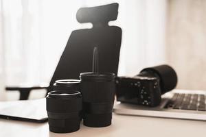 posto di lavoro con un' moderno attrezzatura per fotografia. mirrorless telecamera e primo lenti a contatto. foto