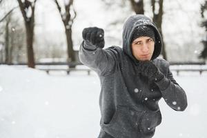 combattente boxe durante il suo inverno allenarsi nel nevoso parco foto