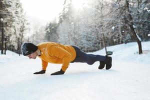 atletico uomo fare spingere UPS durante il suo ginnastica ritmica inverno allenarsi foto