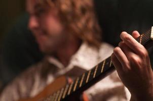 giovane musicista giochi il suo acustico chitarra foto