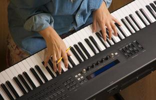 donna di dita su digitale pianoforte chiavi foto