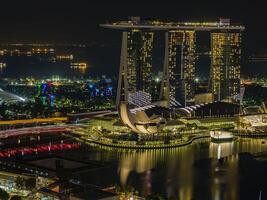 aereo panoramico immagine di Singapore orizzonte e giardini di il baia durante preparazione per formula 1 gara nel il notte nel autunno foto