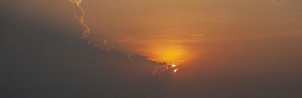 immagine di drammatico e colorato cielo con sole durante tramonto foto