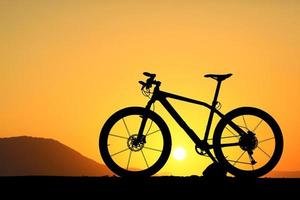 silhouette di un' bicicletta su tramonto foto