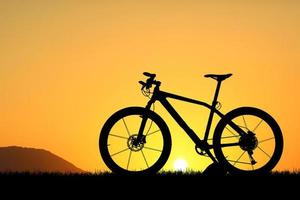 silhouette di un' bicicletta su tramonto foto