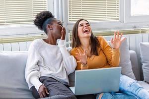 fidanzata Guardando un' molto divertente film su il computer portatile. sorridente giovane donne rilassante e Guardando film a casa, femmina amici avendo riposo dopo difficile settimana, copia spazio foto