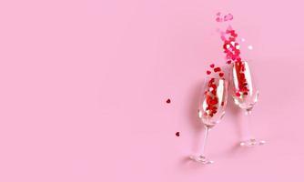 Due tintinnante Champagne bicchieri con spruzzo di rosso cuore sagomato coriandoli al di sopra di rosa sfondo. alto Visualizza, copia spazio. 3d interpretazione illustrazione. foto