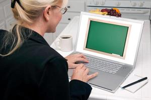 donna nel cucina utilizzando il computer portatile - lavagna foto
