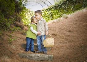 Due bambini con cestino abbracciare al di fuori su passaggi foto