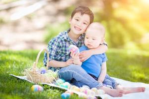 misto gara Cinese e caucasico ragazzi al di fuori nel parco giocando con Pasqua uova foto