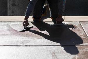 costruzione lavoratore levigante bagnato cemento con cazzuola utensili foto