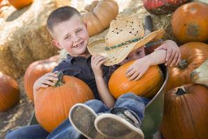 Due poco ragazzi giocando nel carriola a il zucca toppa foto