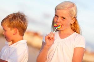 carino poco ragazza e fratello godendo loro Lecca-lecca foto