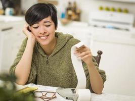 multietnico giovane donna sorridente al di sopra di finanziario calcoli foto