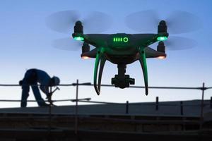 silhouette di senza equipaggio aereo sistema quadcopter fuco nel il aria a costruzione luogo foto