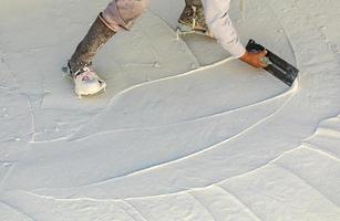 lavoratore indossare spillo scarpe levigante bagnato piscina gesso con cazzuola foto