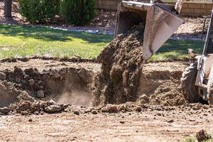 piccolo bulldozer scavando nel cortile per piscina installazione foto