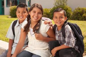 giovane ispanico alunno bambini indossare zaini su scuola città universitaria foto