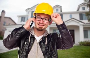 contraente indossare difficile cappello su Telefono nel davanti di Casa foto