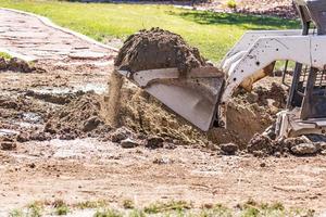 piccolo bulldozer scavando nel cortile per piscina installazione foto