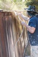 professionale pittore spruzzatura cortile recinto con macchia foto