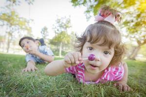 carino bambino ragazza e fratello con Lecca-lecca nel parco foto