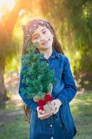 carino misto gara giovane ragazza Tenere piccolo Natale albero all'aperto foto