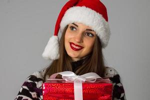 donna nel caldo maglione e Santa cappello con rosso regalo foto