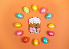 colore Pasqua uova di cui su nel cerchio e Pan di zenzero Pasqua torta nel centro su arancia sfondo. festivo Pasqua disposizione. foto