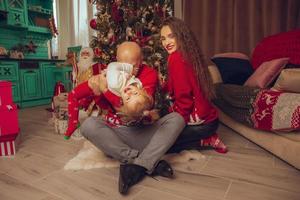orizzontale foto di divertente famiglia con figlia celebrare nuovo anno e Natale insieme a casa