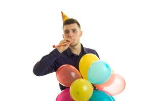 contento giovane uomo soffiaggio corno su compleanno festa foto